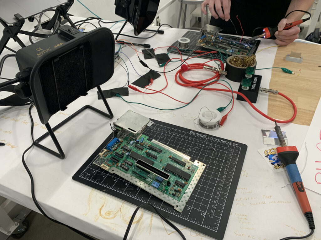 Two soldering kits set up across from each other, so that folks can play the soldering game. 